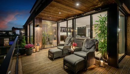 Moderne og komfortabel terrasse med stoler og bord og tre terrassevarmere, perfekt for avslapning utendørs.