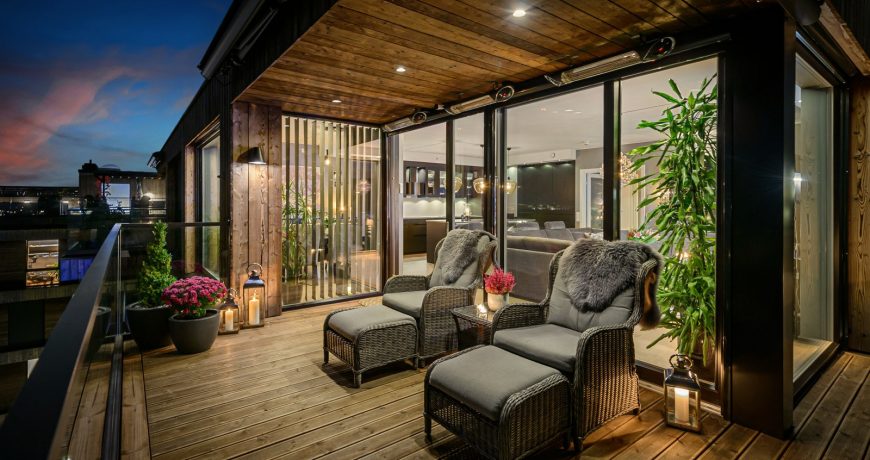 Moderne og komfortabel terrasse med stoler og bord og tre terrassevarmere, perfekt for avslapning utendørs.
